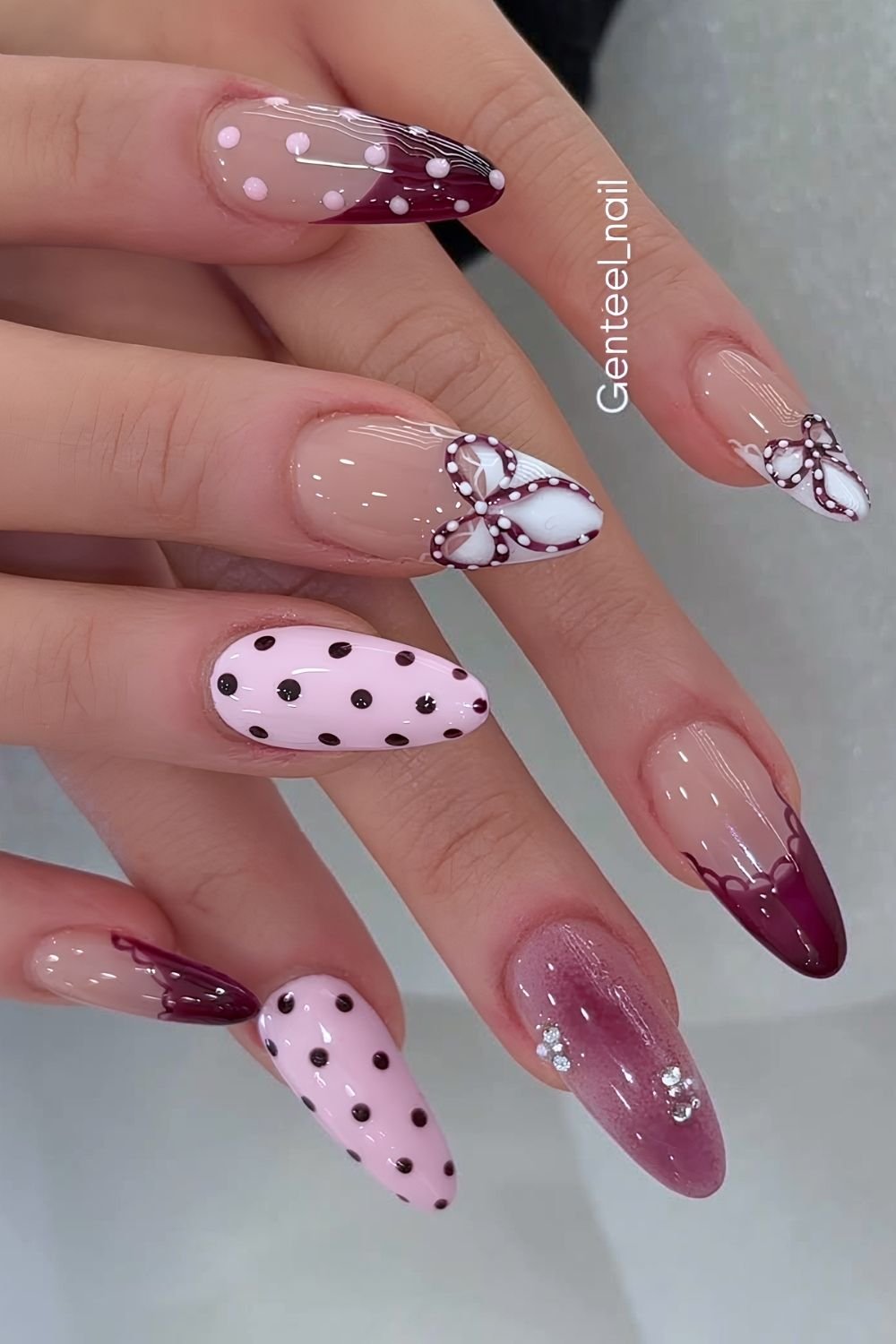 Burgundy and pink polka dot mani with dotted bow accents