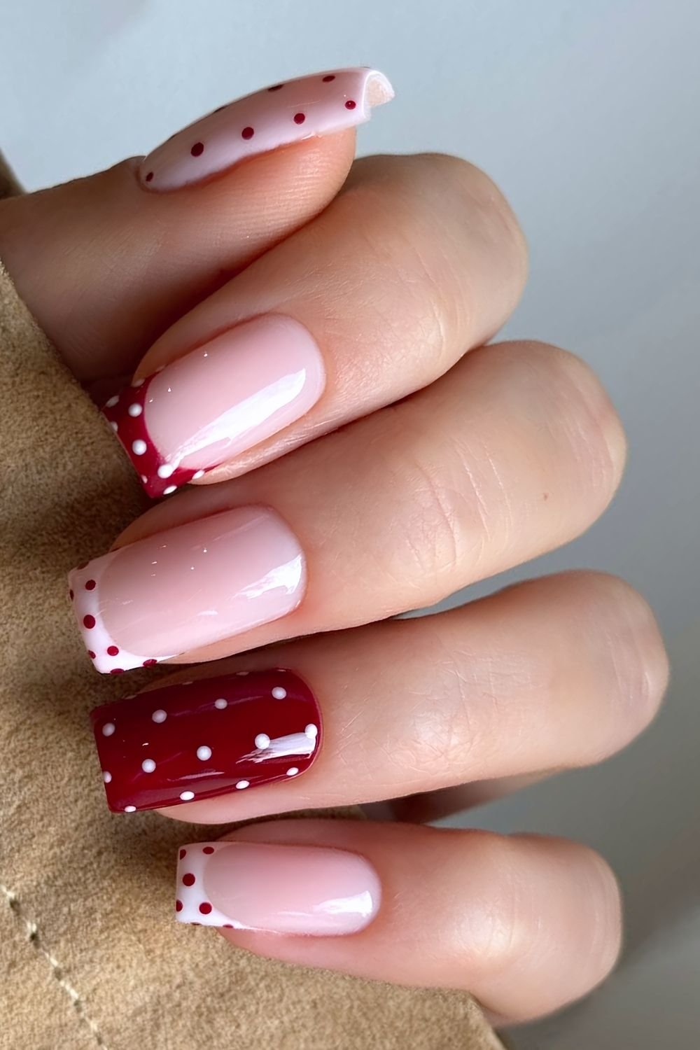 Cherry red and baby pink polka dot nails with French tip accents