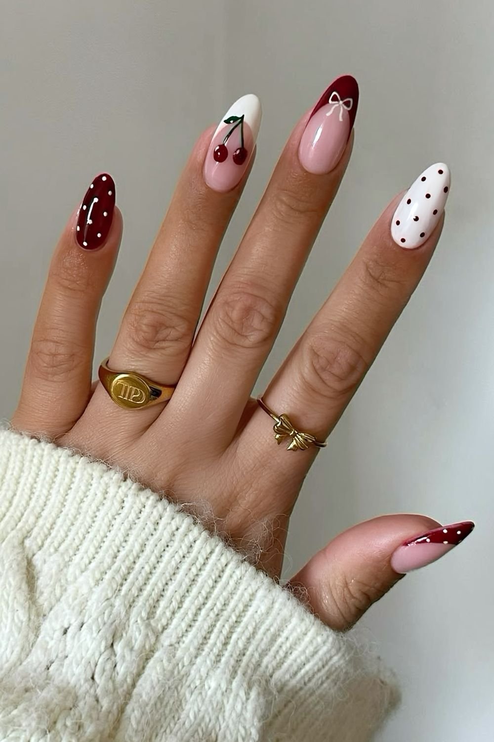 Dark red and white polka dot nails with bow and cherry accents