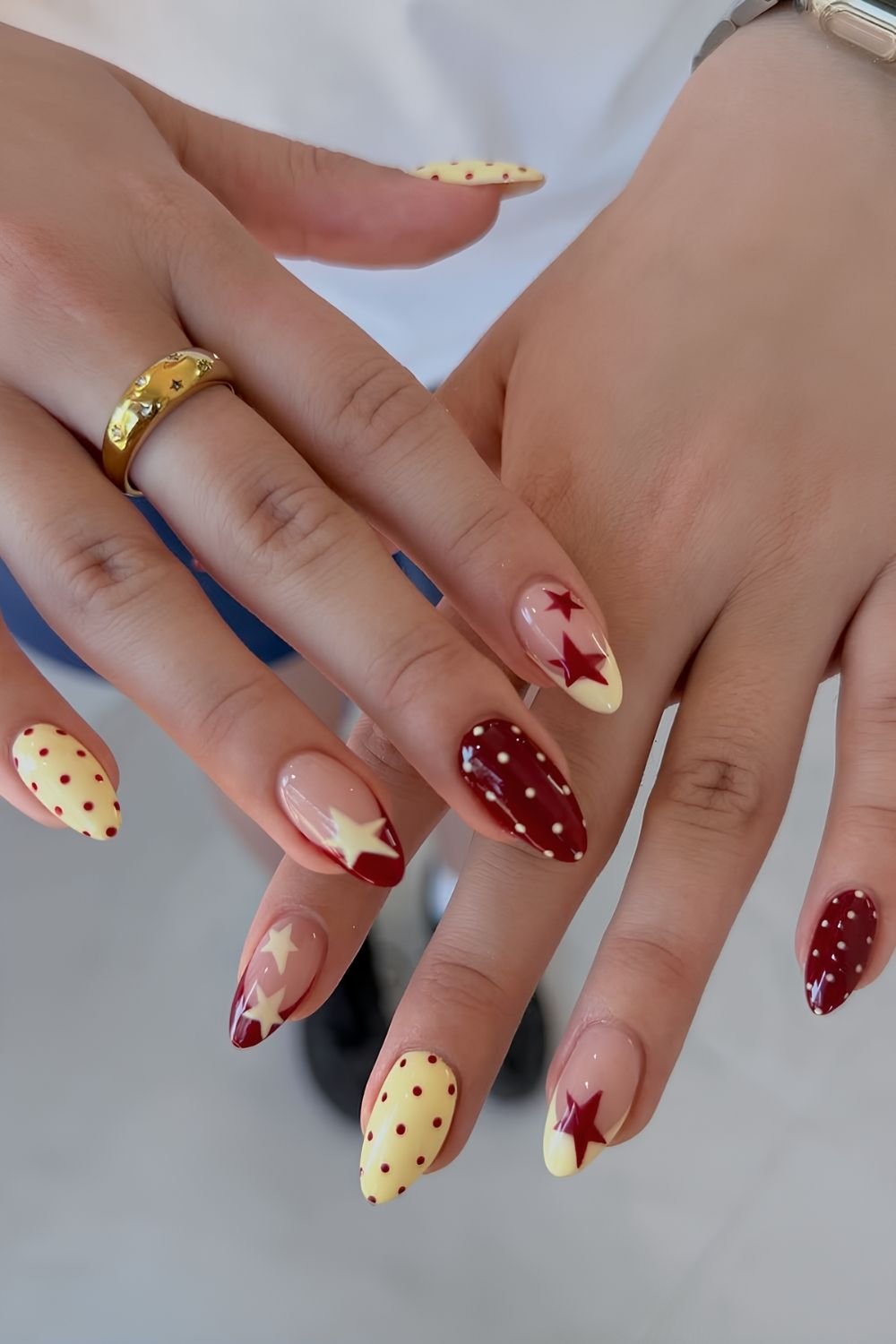Dark red and yellow polka dot nails with stars