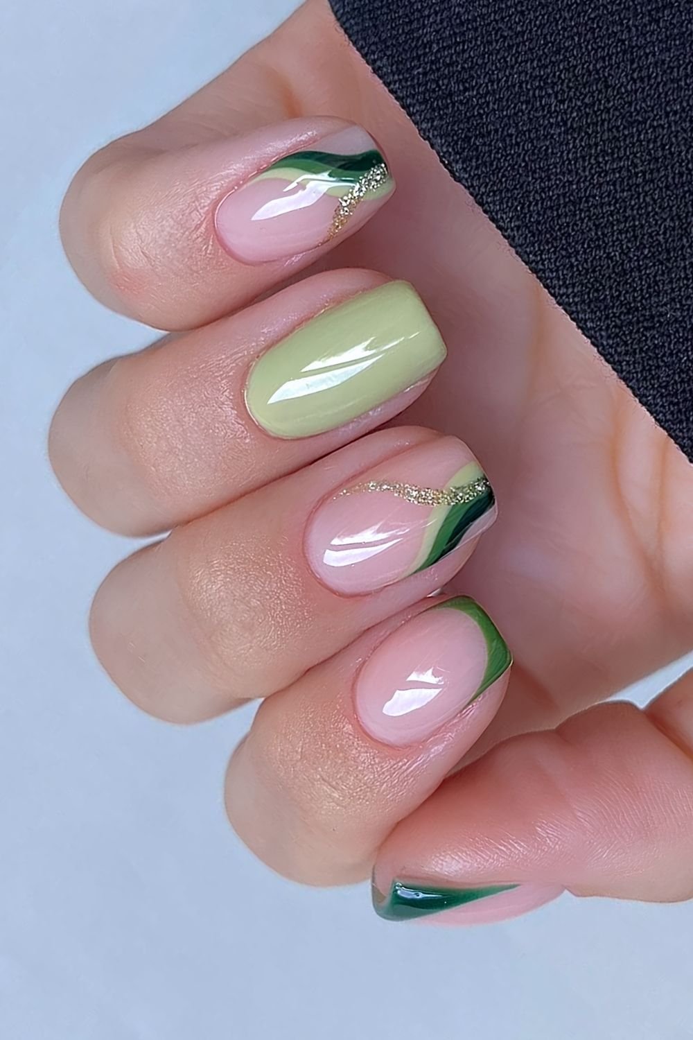 Green and neutral nails with gold and green swirls