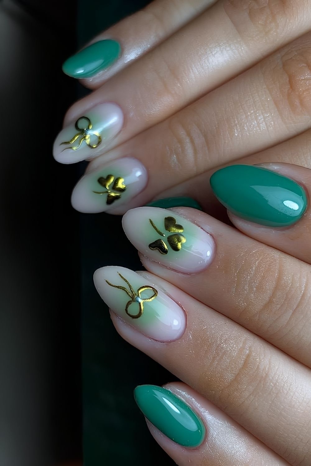 Green aura nails with golden chrome bows and shamrocks centered
