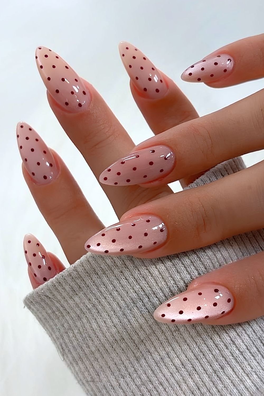 Pink and brown polka dot nails with cat-eye effect
