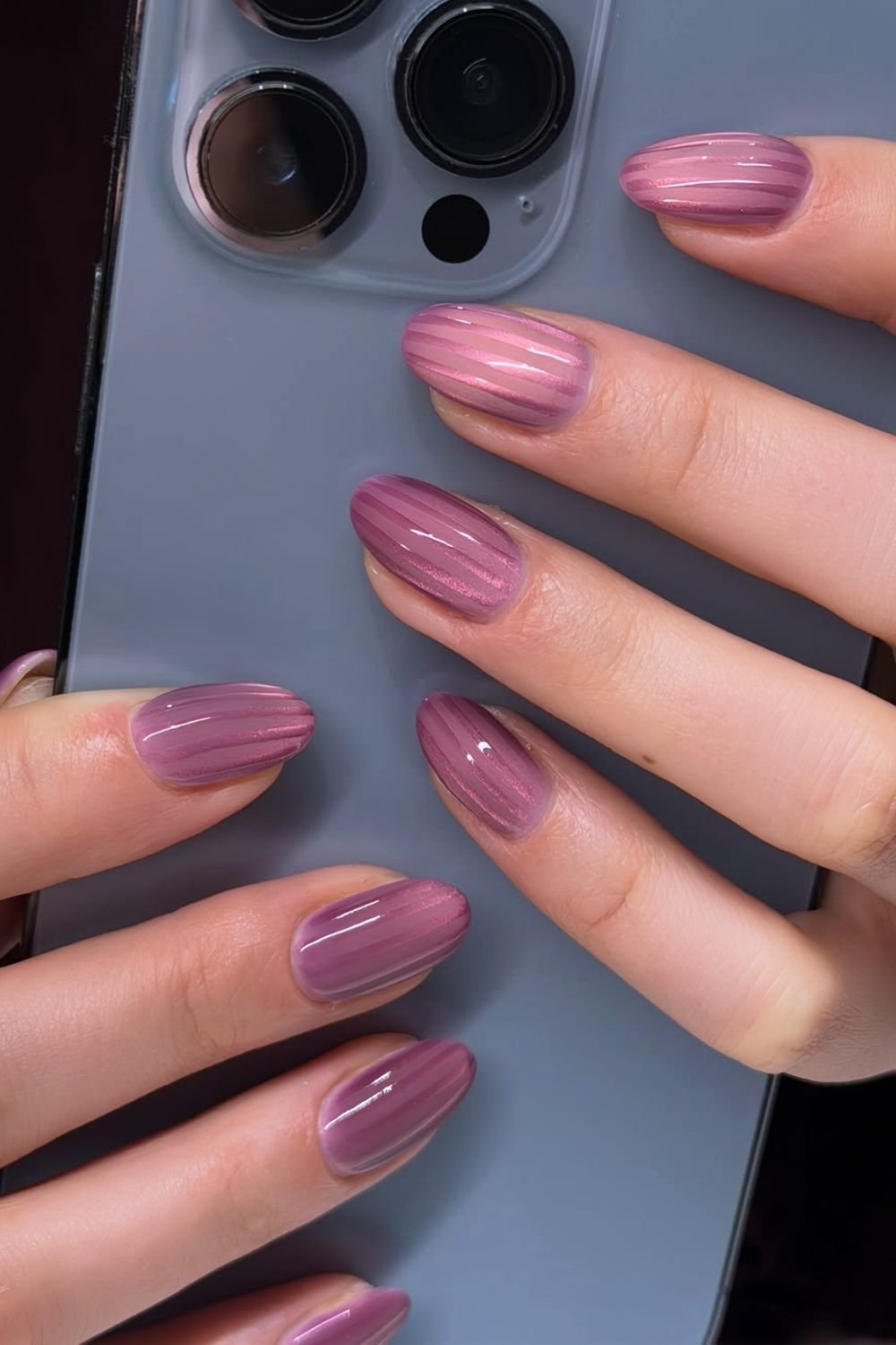 Stripe cat eye nails in different shades of plum purple