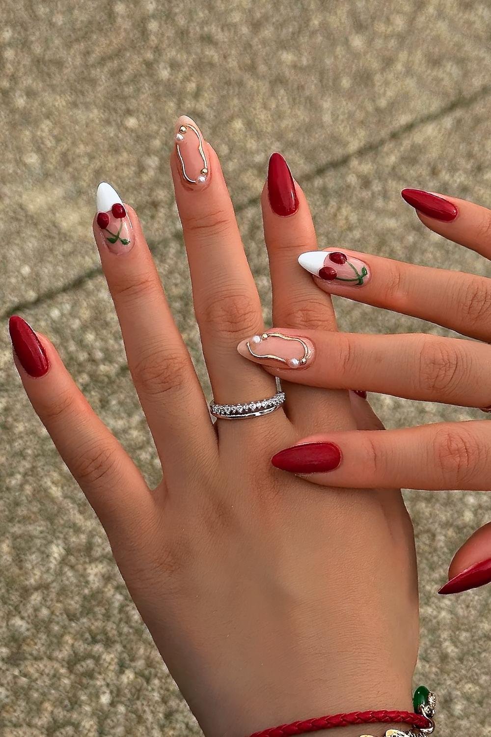 Cherry red nails and white French tips with cherry and gold chrome accents