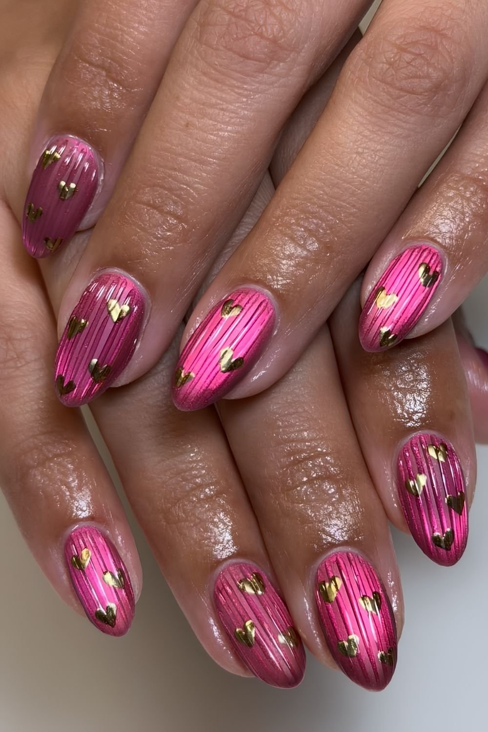 Hot pink ribbed glass nails with golden heart accents