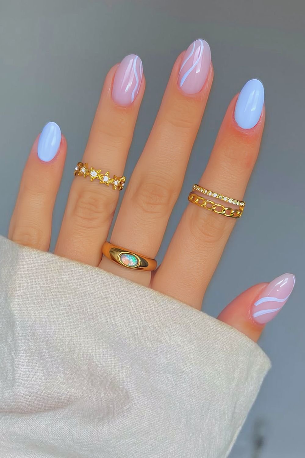 Light blue BIAB nails with swirl accents
