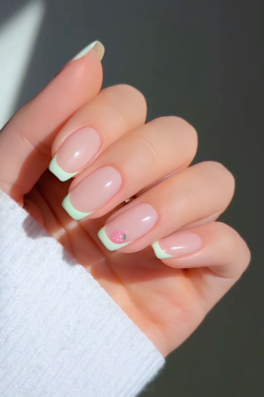 Matcha green French tips with pink strawberry nail art
