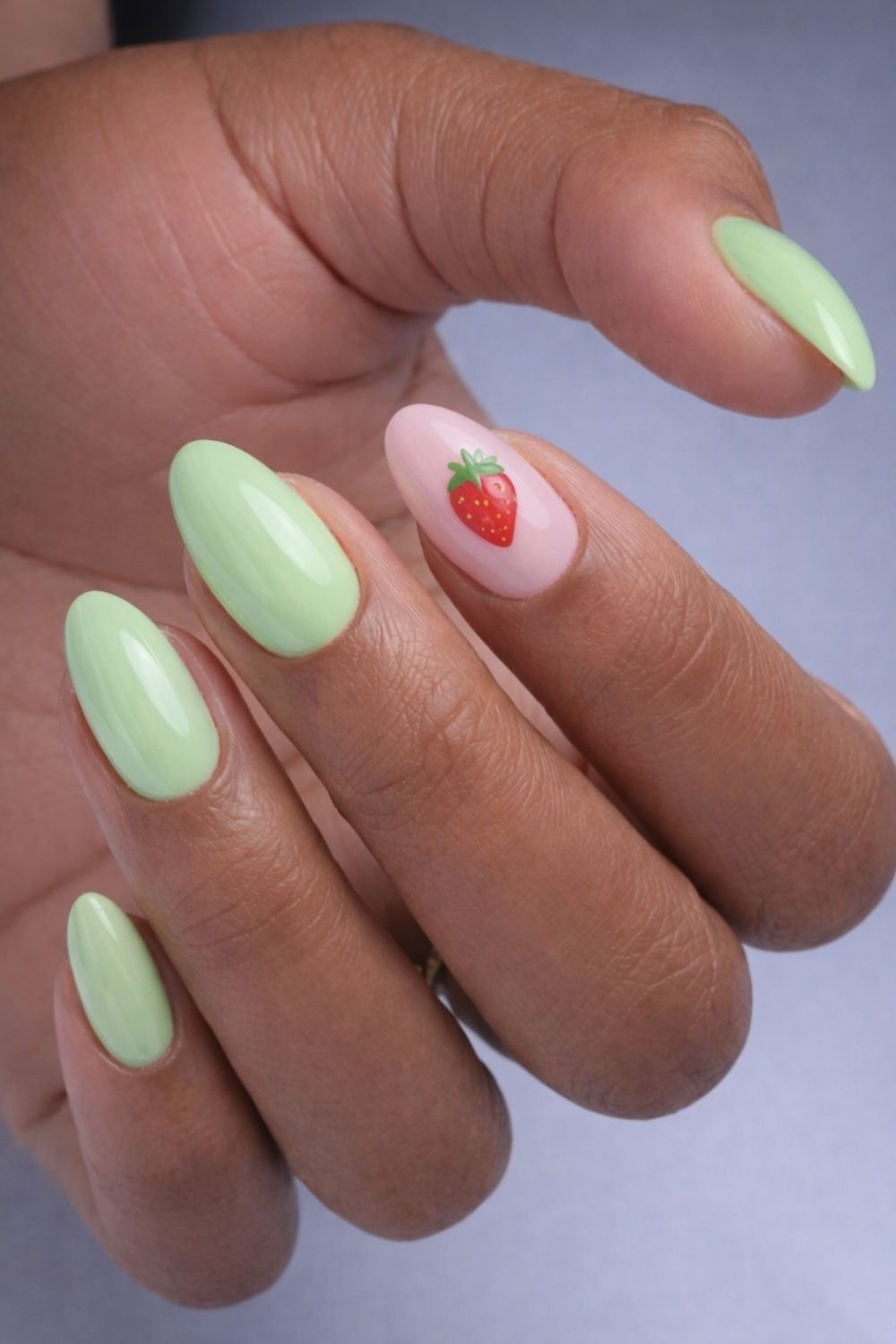 Matcha nails with pink accent and strawberry nail art