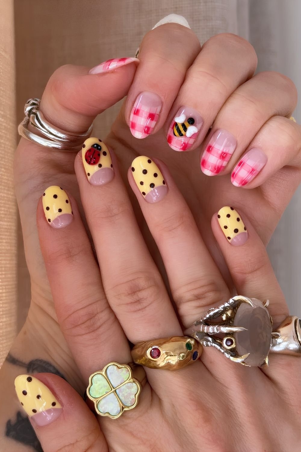 Mismatched hands nail design with polka dots with ladybugs and gingham with bees