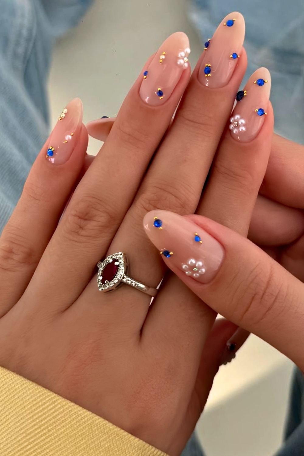 Neutral nails with sapphire blue gems, white pearls and gold studs