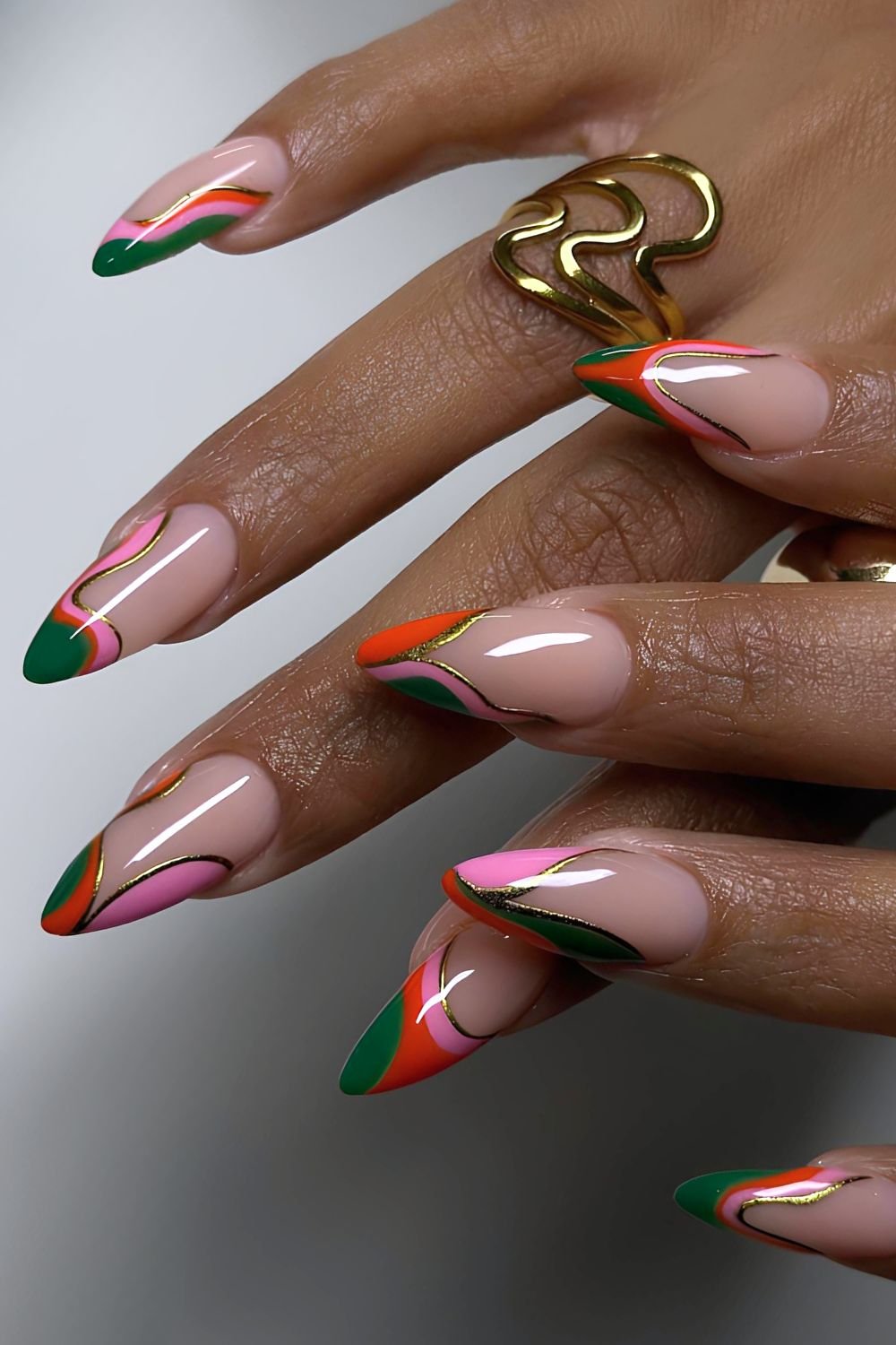 Abstract French nails in green, pink and red with gold outline