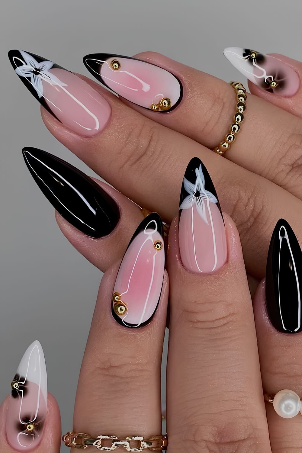 Black and pink floral nails wit aura and golden stud accents