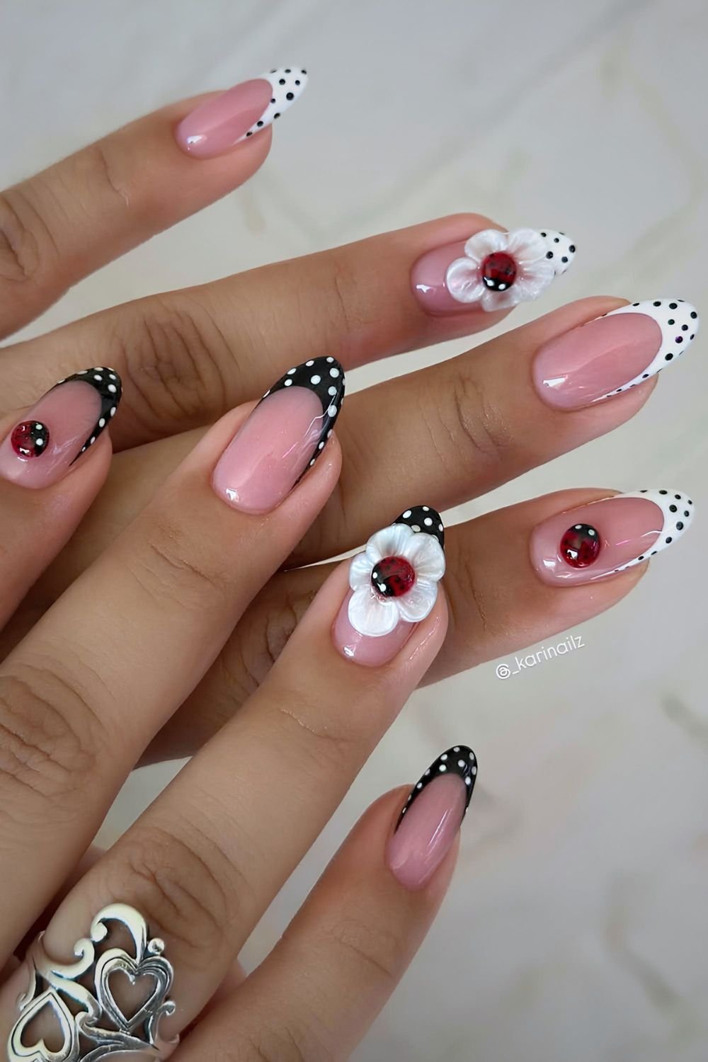 Black and white polka dot French mani with 3D flower centered ladybug