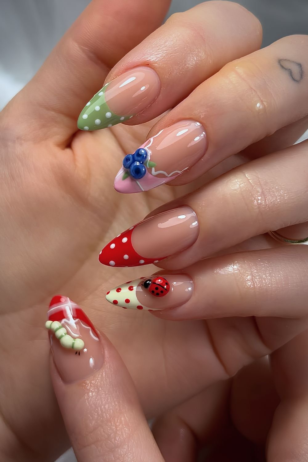 Colorful french tips with polka dot and gingham pattern with 3D blueberries, ladybugs and worm accents