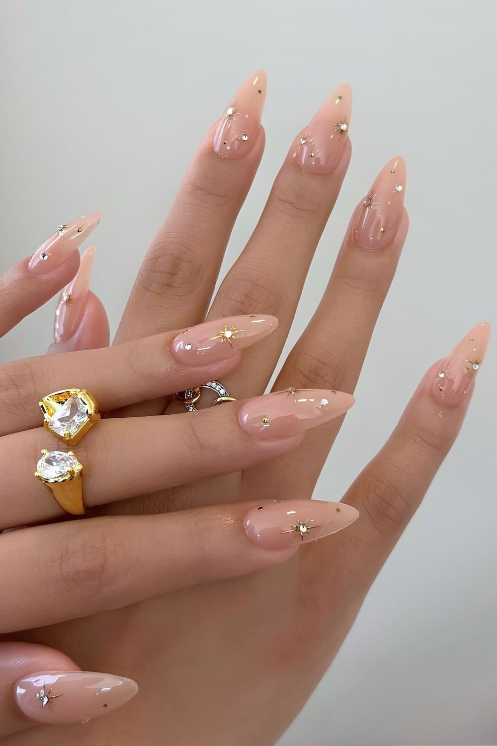 Glossy neutral nails with gold celestial studs