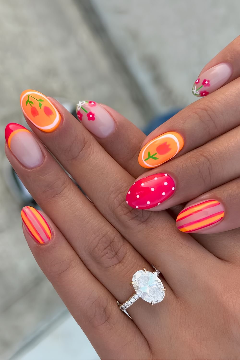 Hot pink and neon orange nails with strips, polka dots and floral art