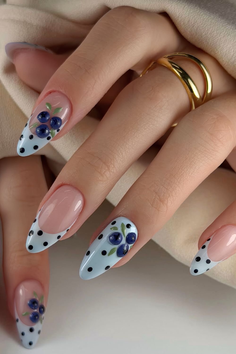 Light blue polka dot nails with accent french tips and blueberries