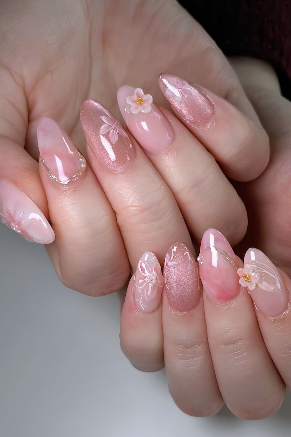Marble and cat-eye nails with sculpted cherry blossom design