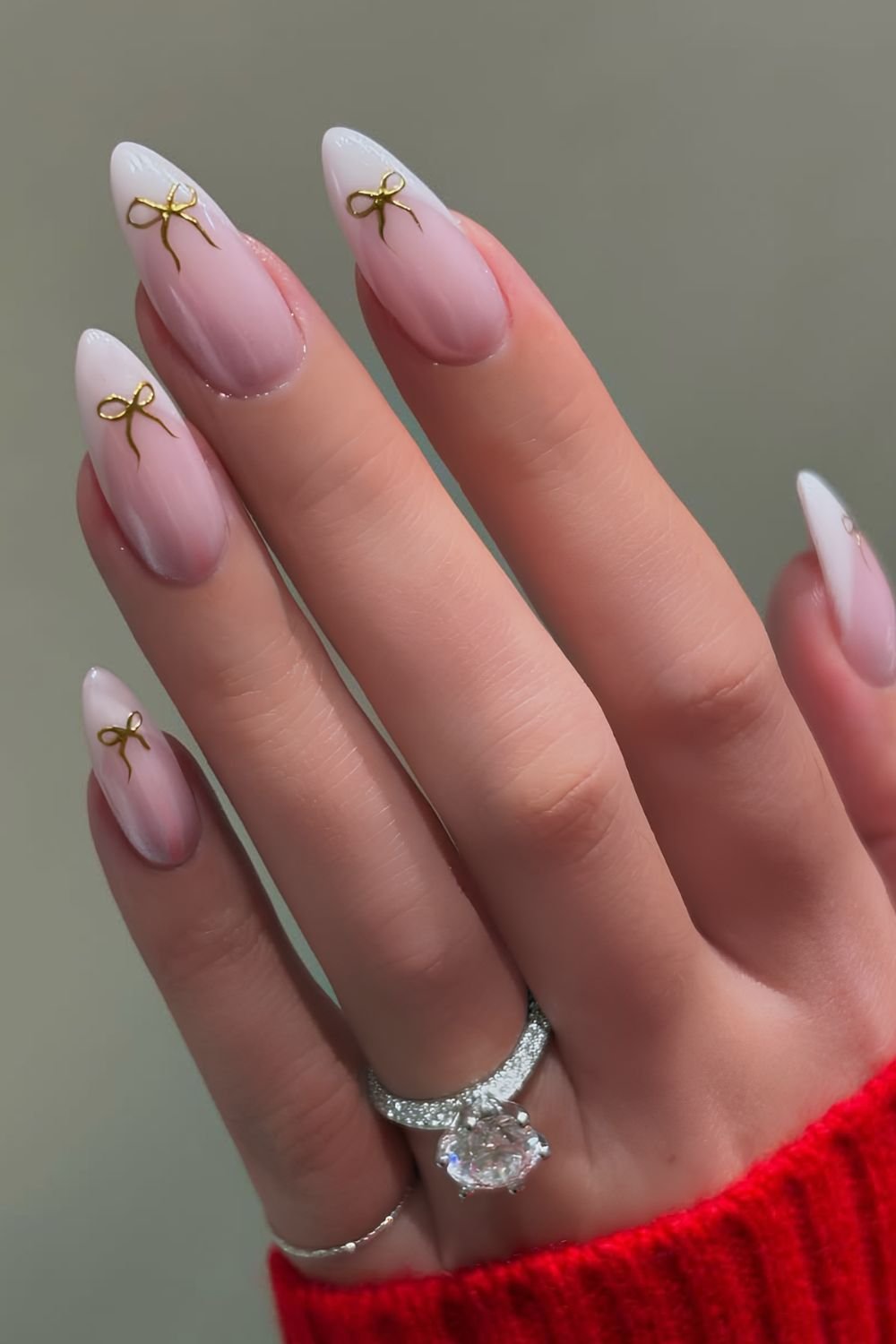 Milky French tip nails with gold chrome bows