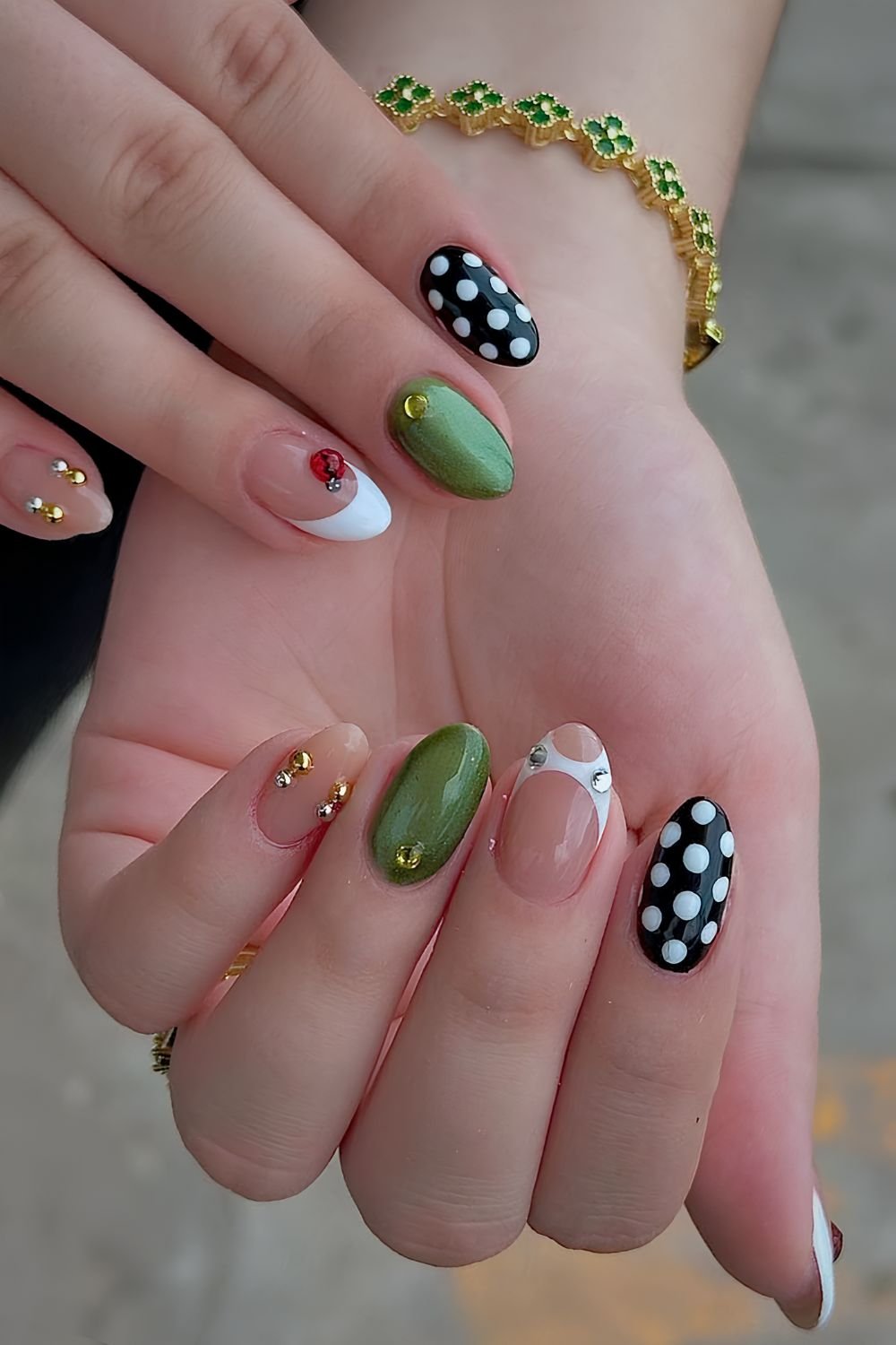 Mix and match nails with green cat eye, black and white polka dots and gold and silver studs
