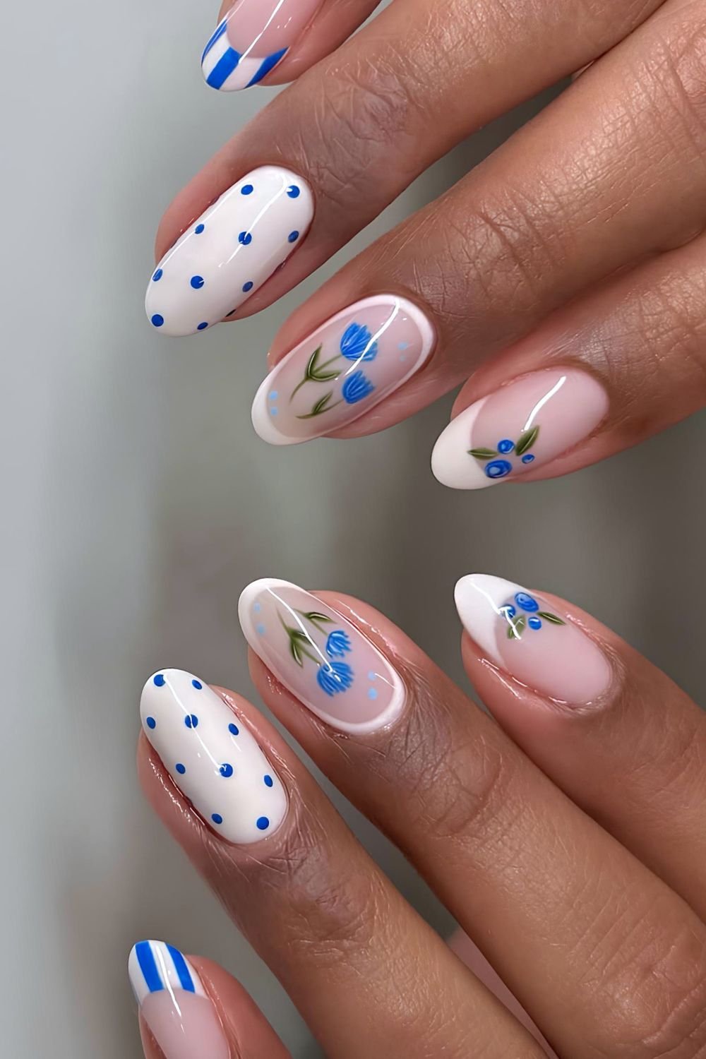 Pale pink nails with blue stripes, dots, flowers and blueberries