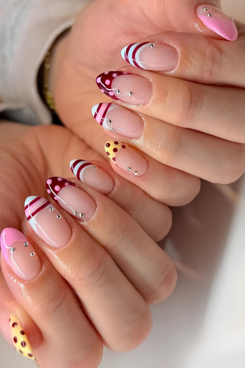 Pastel and dark red stripes and polka dots French tip manicure