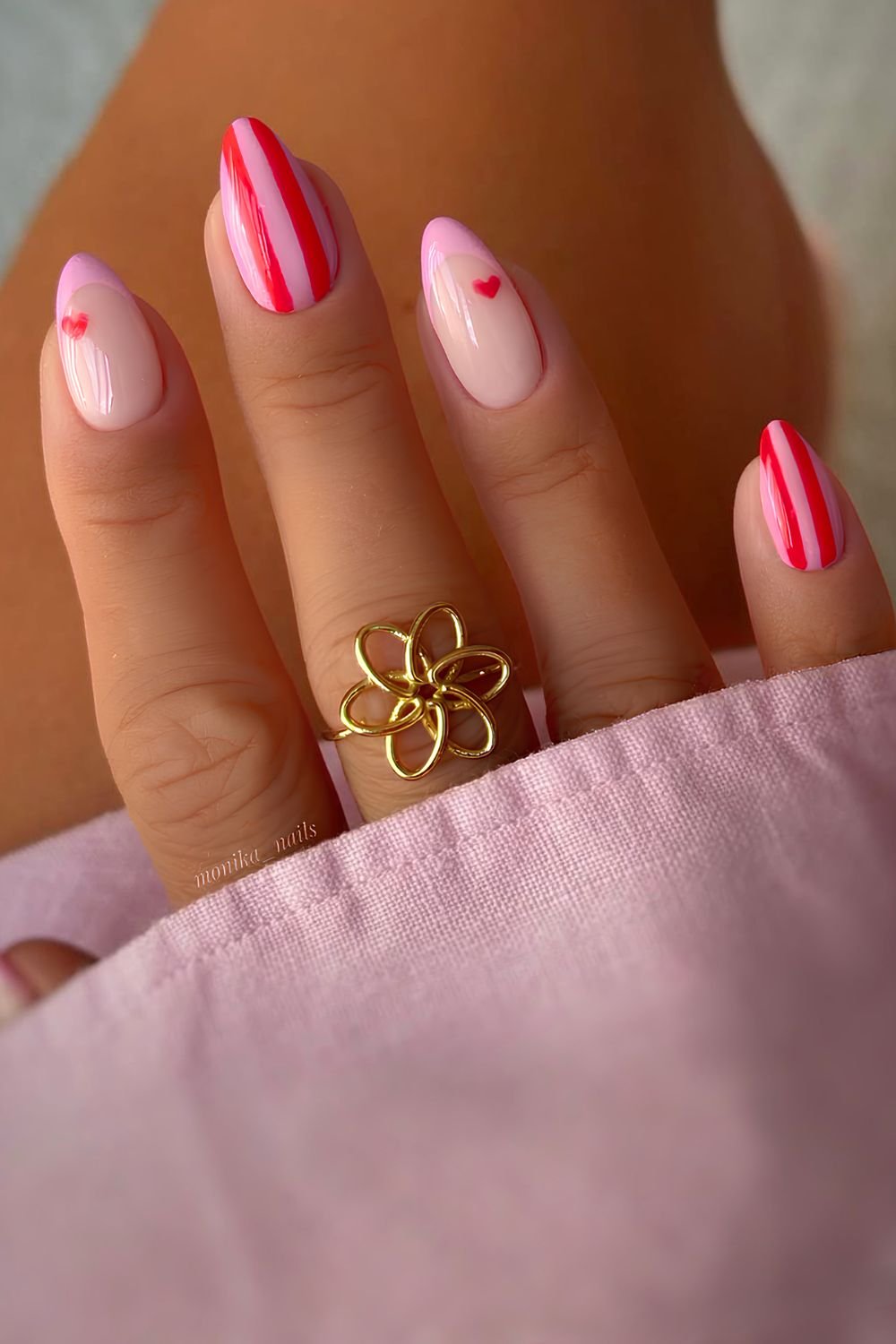 Pink and red striped nails with accent french tips and tiny hearts