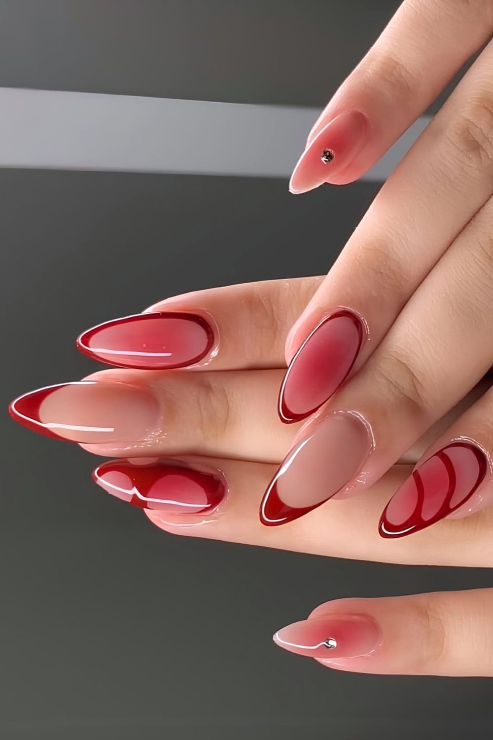 Red aura nails with French tip accents and gems