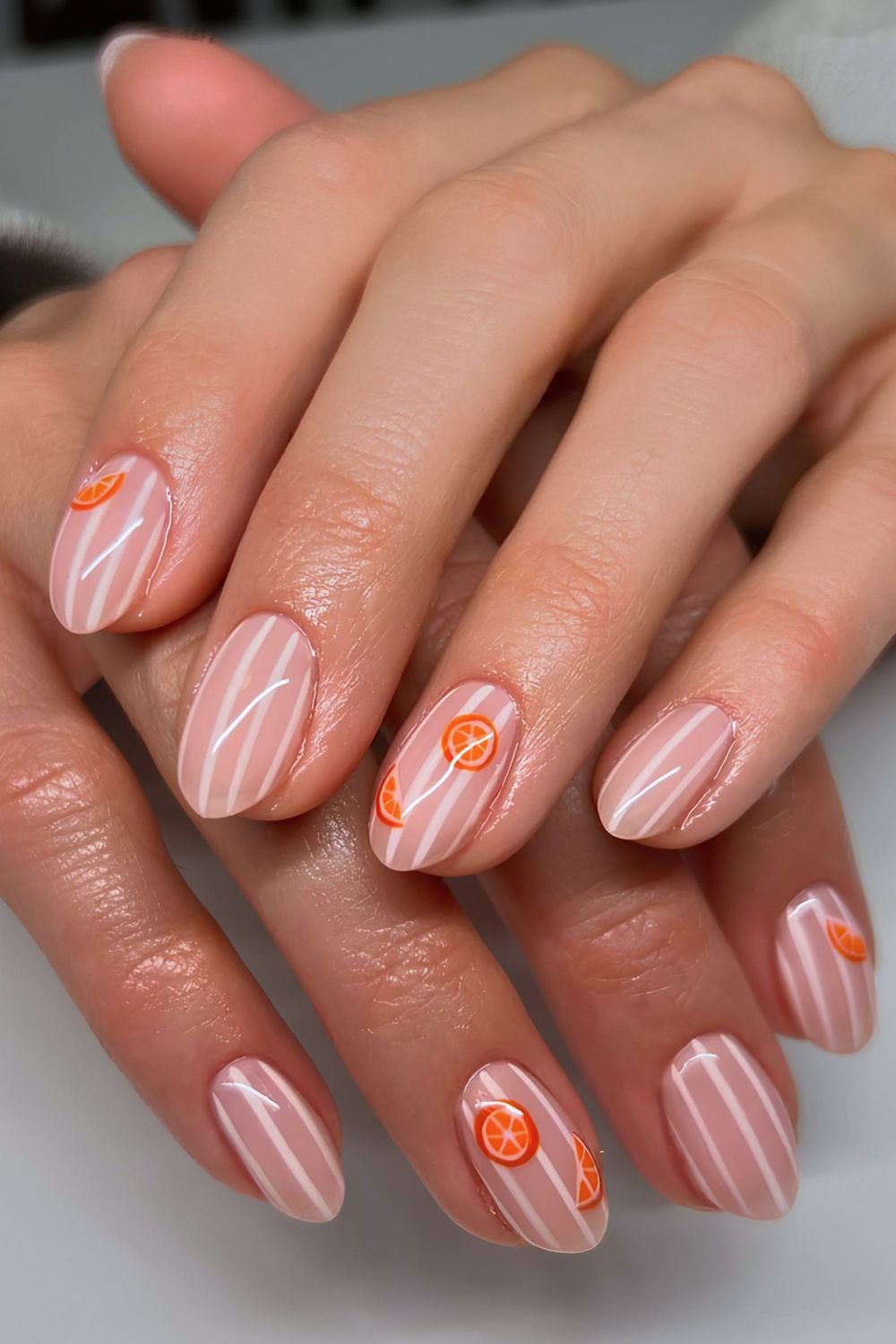Sheer milky white and opaque white striped nails with orange slice art
