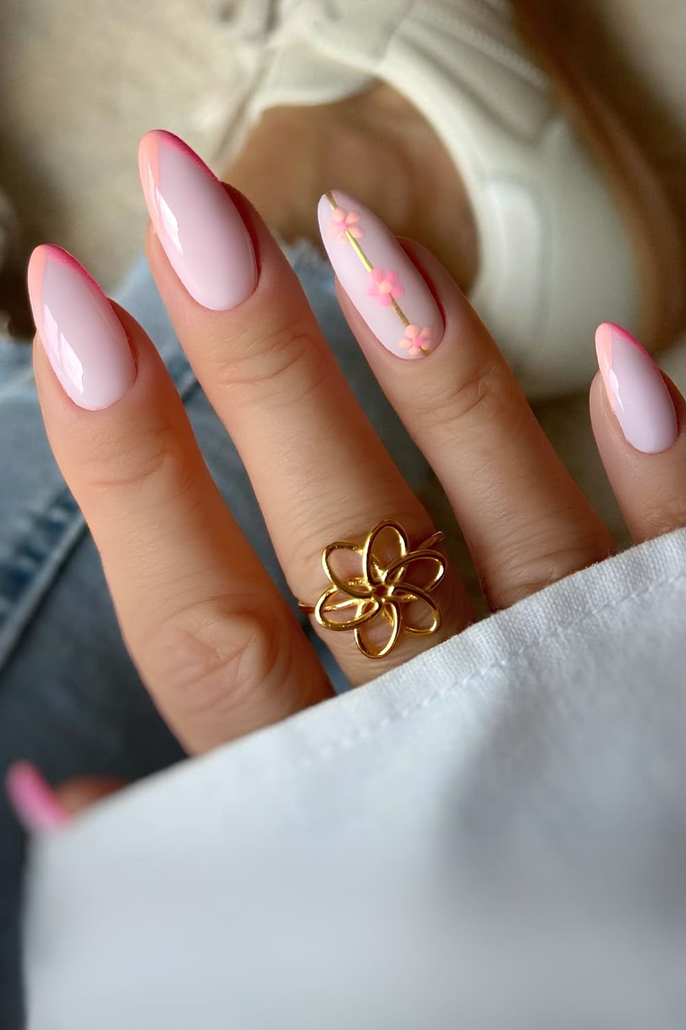 V shaped French tip nails in pink and orange with floral accents