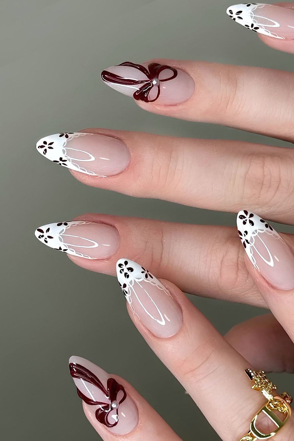 White French nails with brown flowers, lace outlines and bow accent