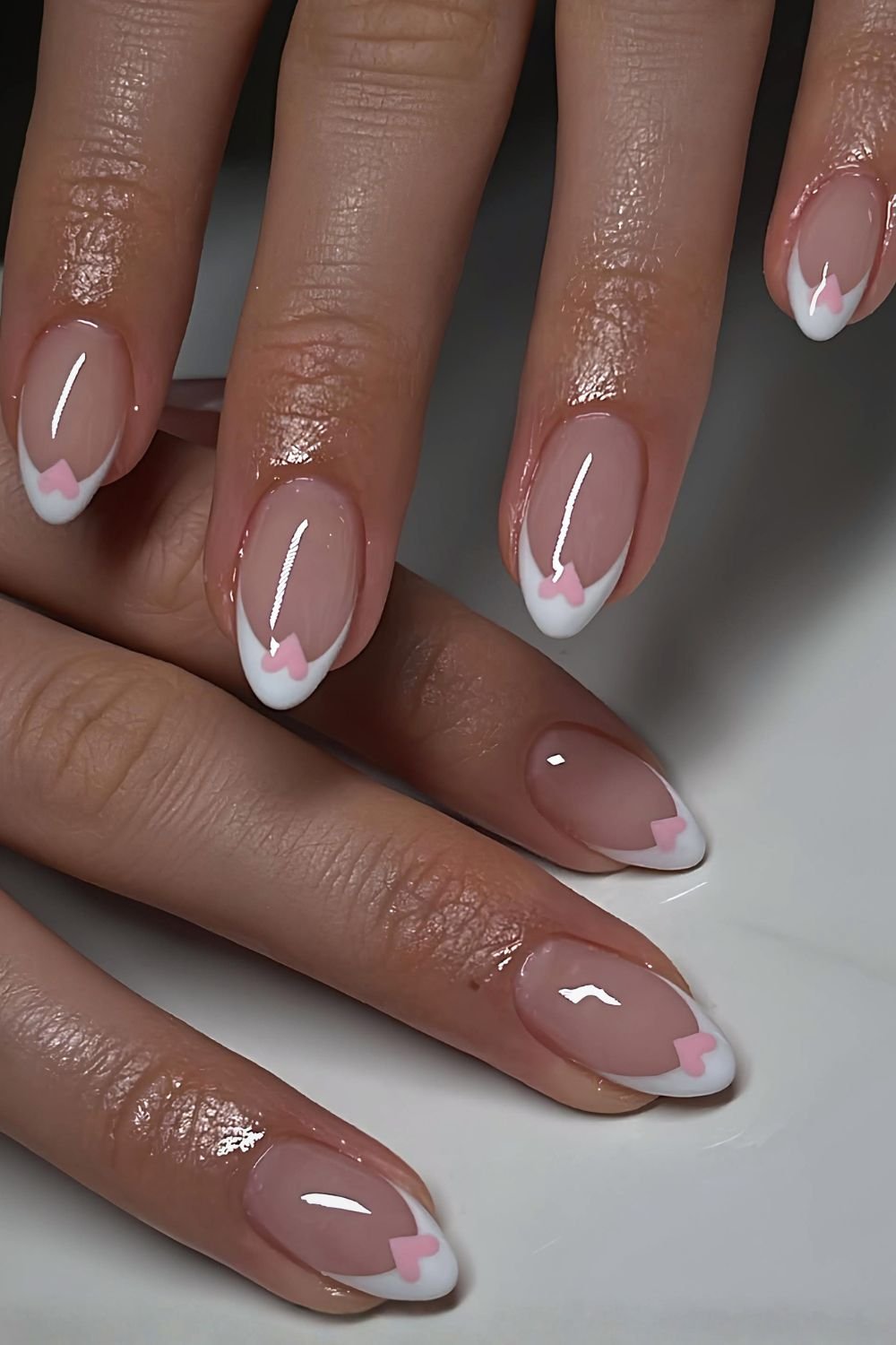 White French tips with pink heart accents