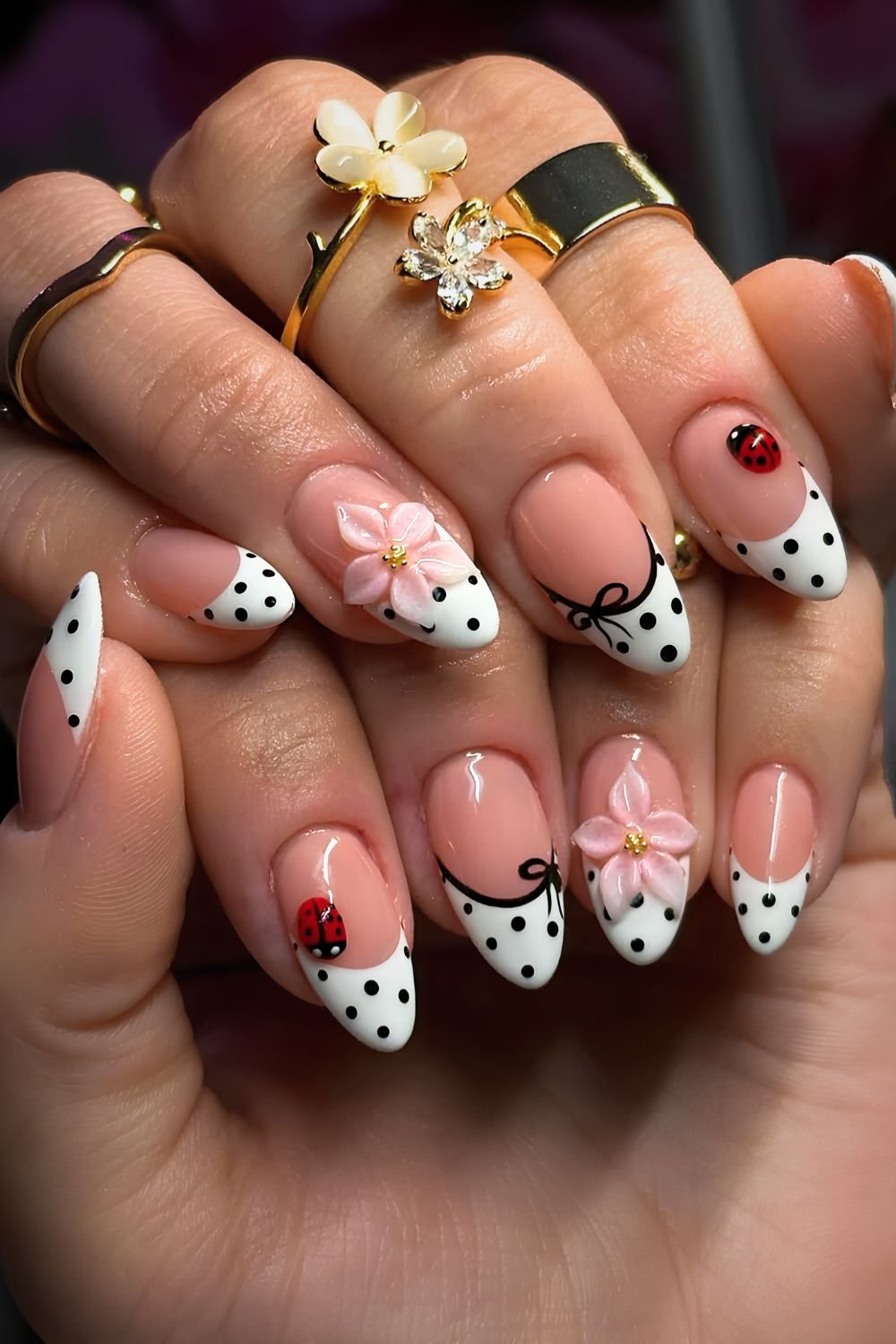 White and black polka dot nails with black bow outlines 3d ladybugs and sculpted flowers