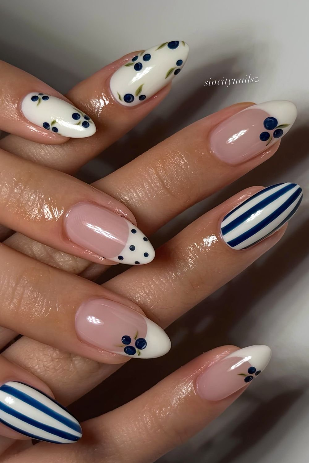 White nails with navy blue stripes, polka dots and blueberry accents
