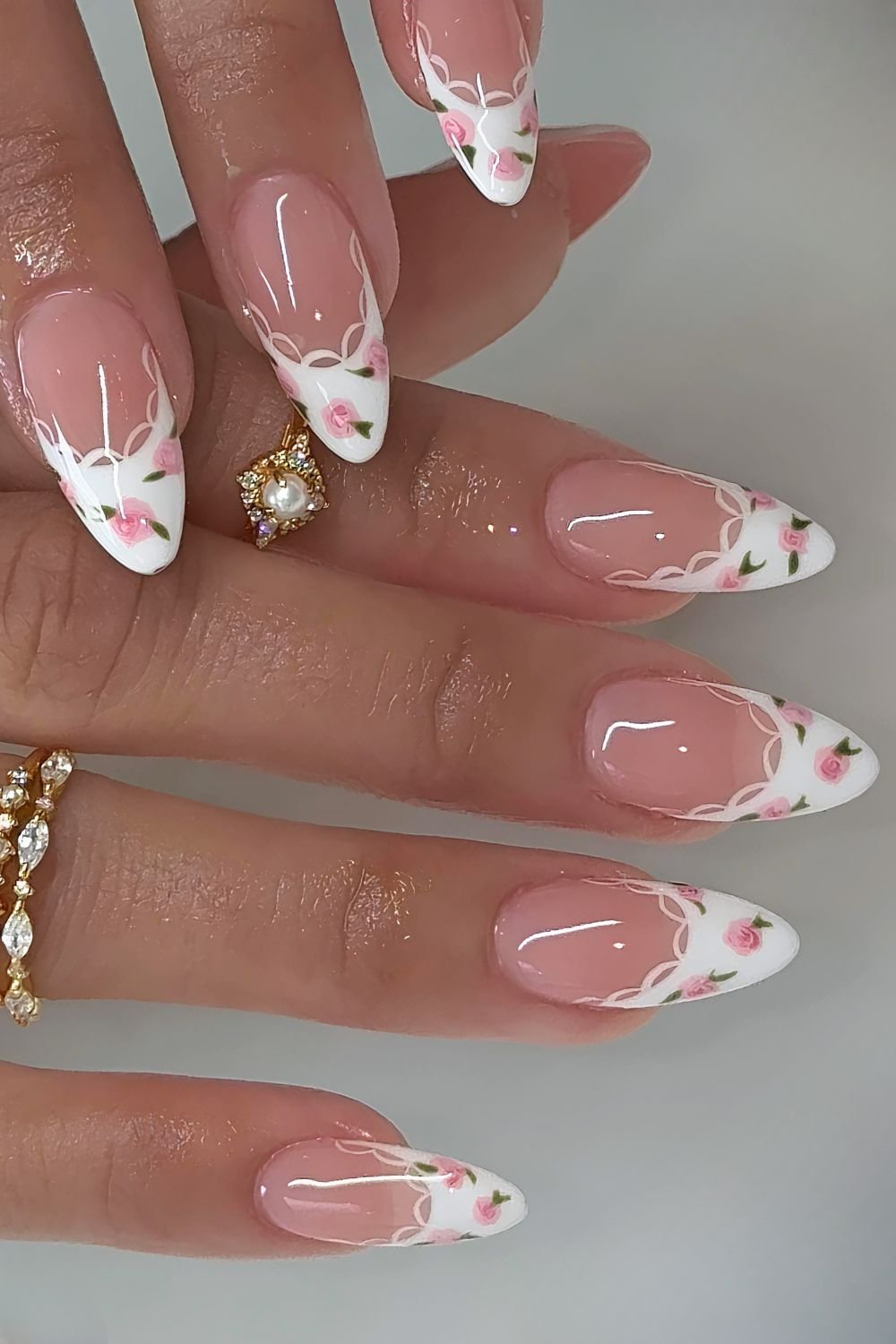 white French tip nails with tiny pink rose design and lace outline