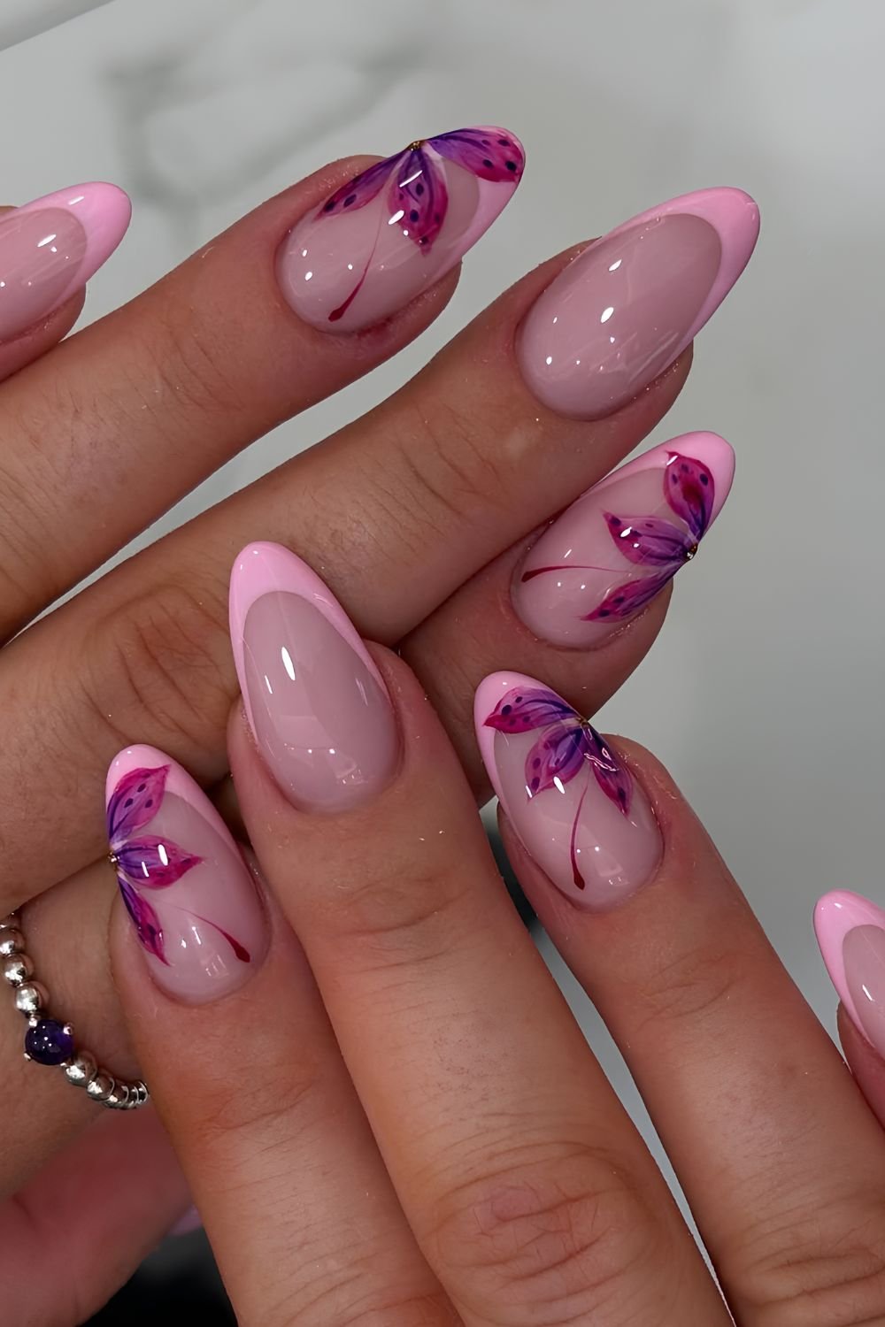 Light pink French nails with large purple flowers