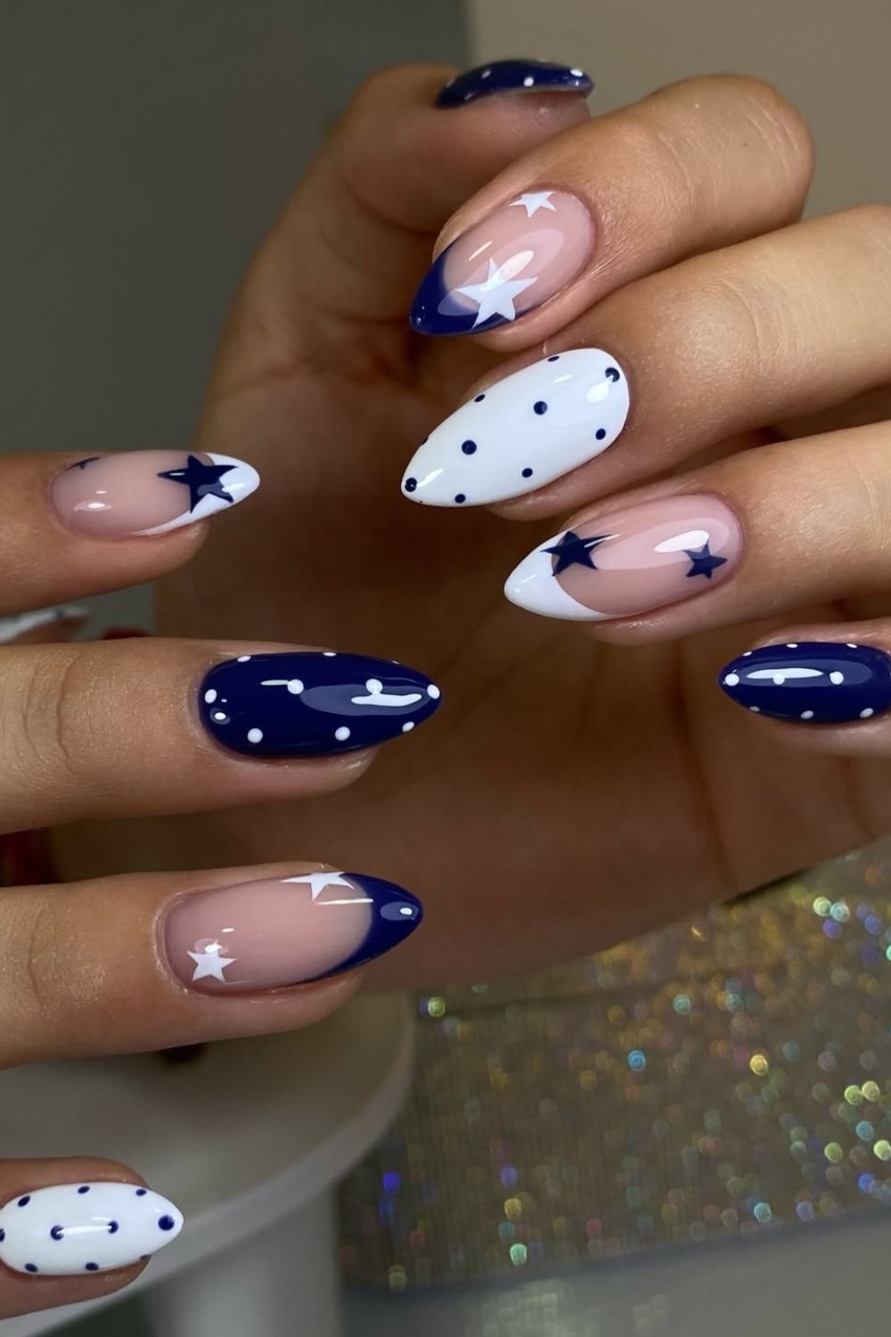 Navy blue and white nails with polka dot and star accents
