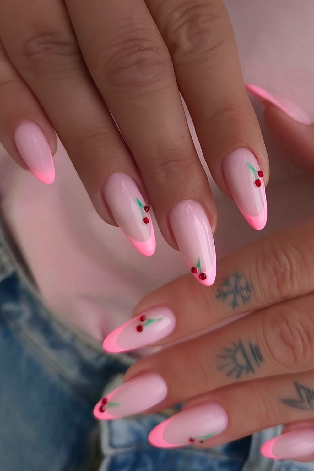Neon pink French tip nails with cherry gem motives