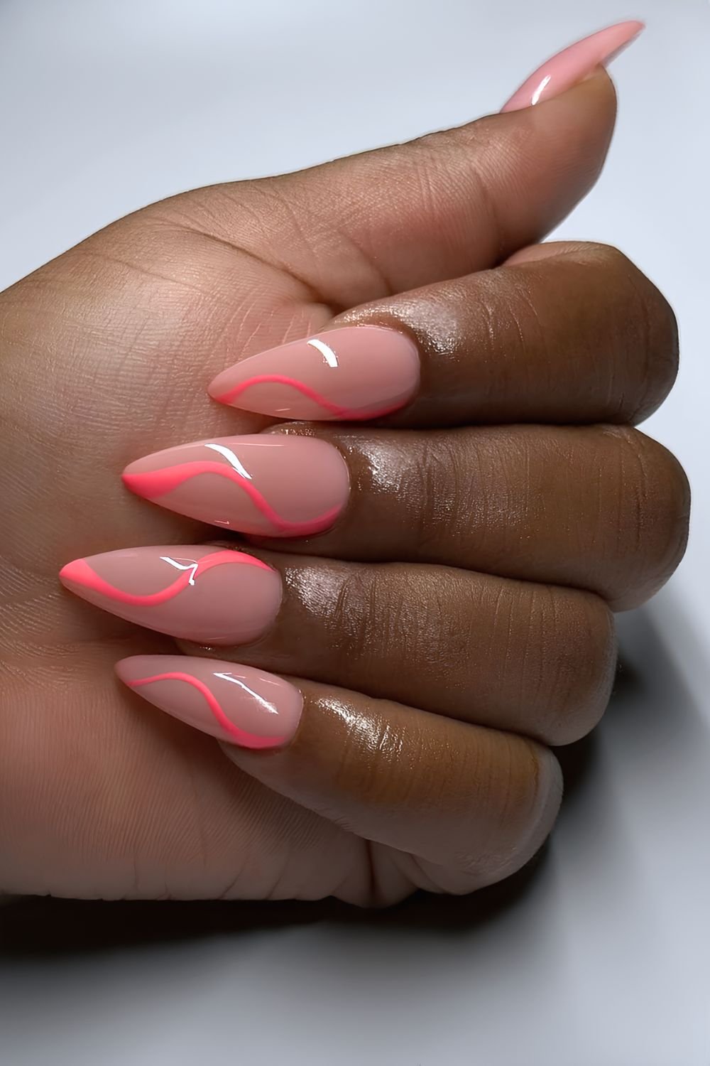 Neutral nails with coral pink swirls