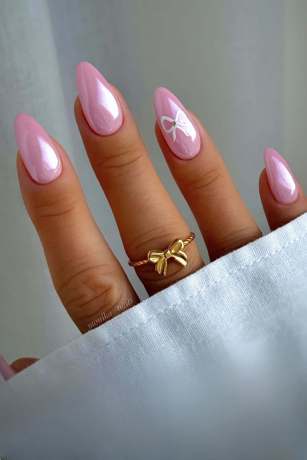 Pink chrome nails with white bow accents