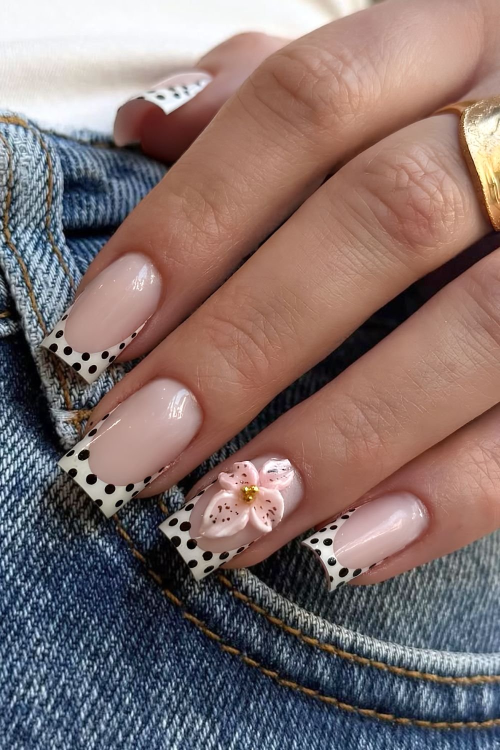 Square-shaped white and black polka-dot French nails with 3D flower accents