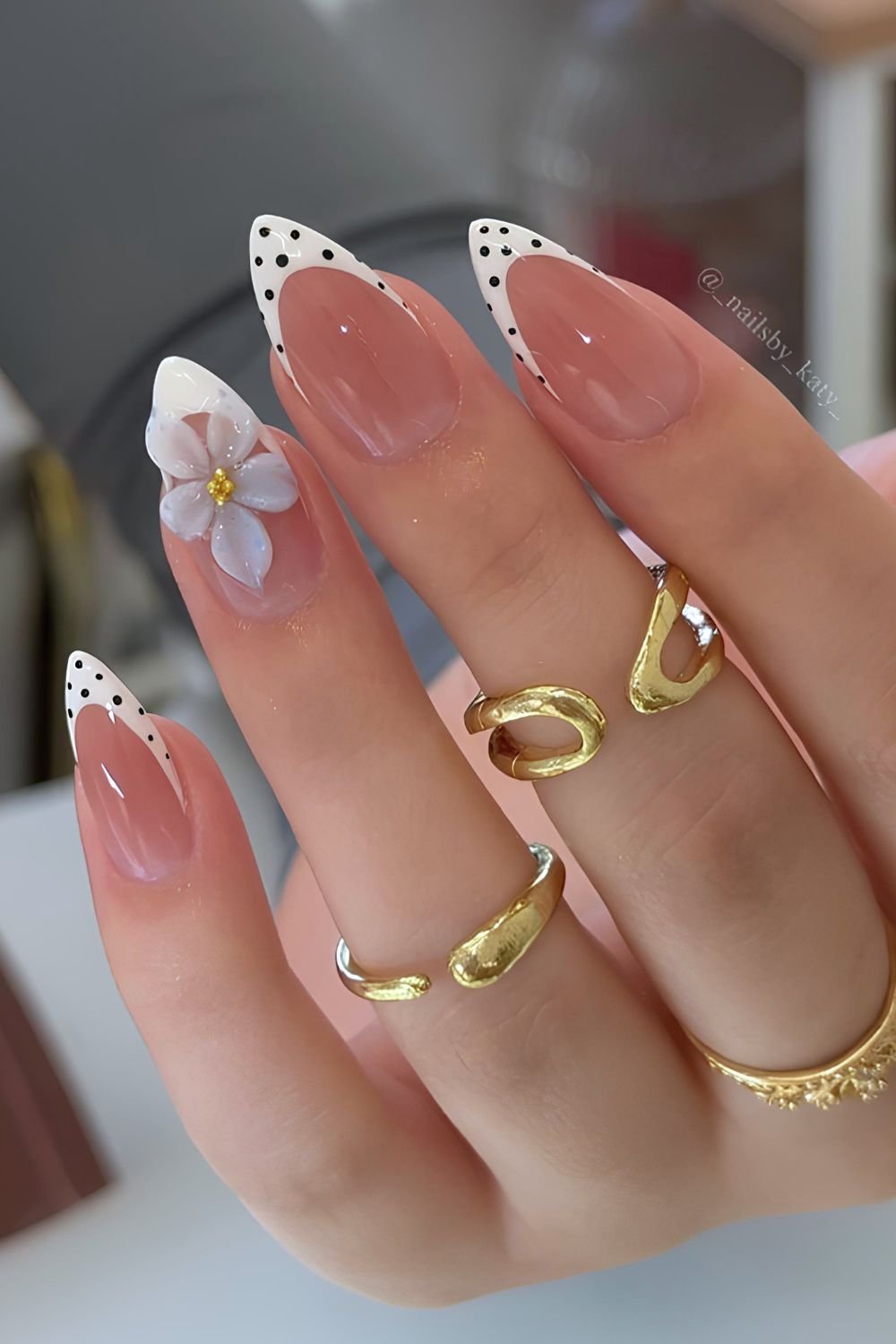 Black and white polka dot nails with blue 3D flower accent