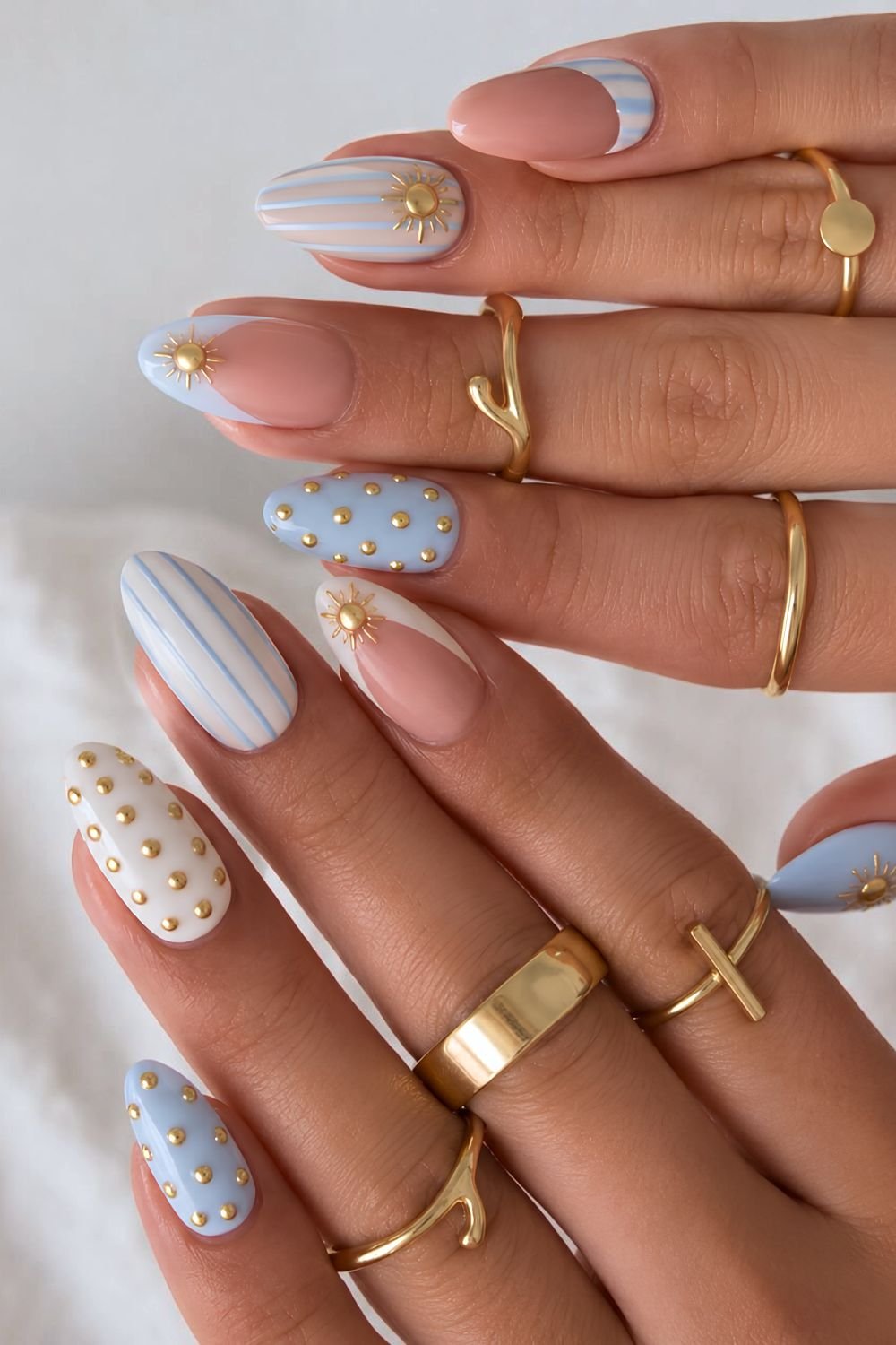 White and blue nails with stripes and gold chrome accents
