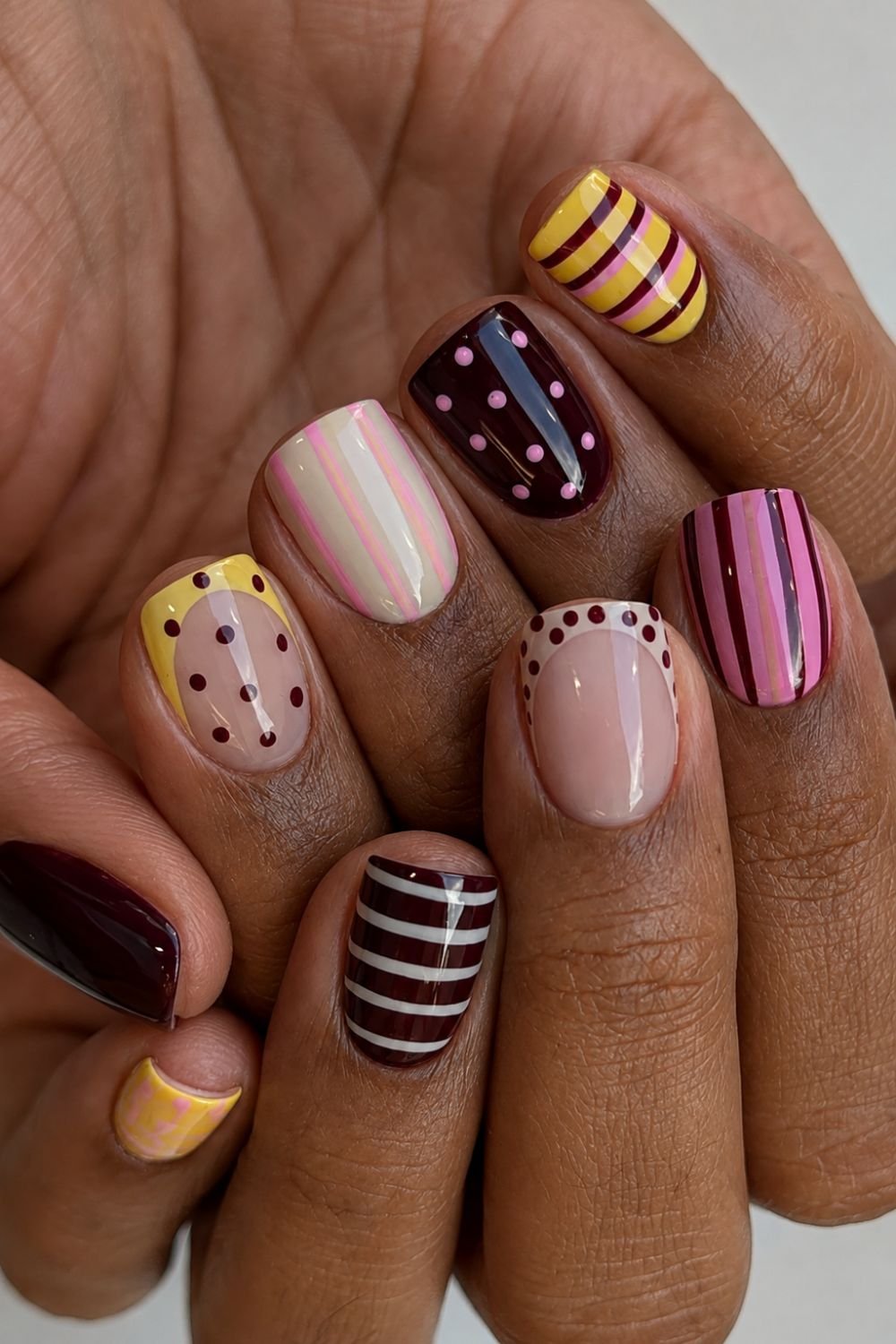 Short polka dot and stripes nails in brown, pink and yellow