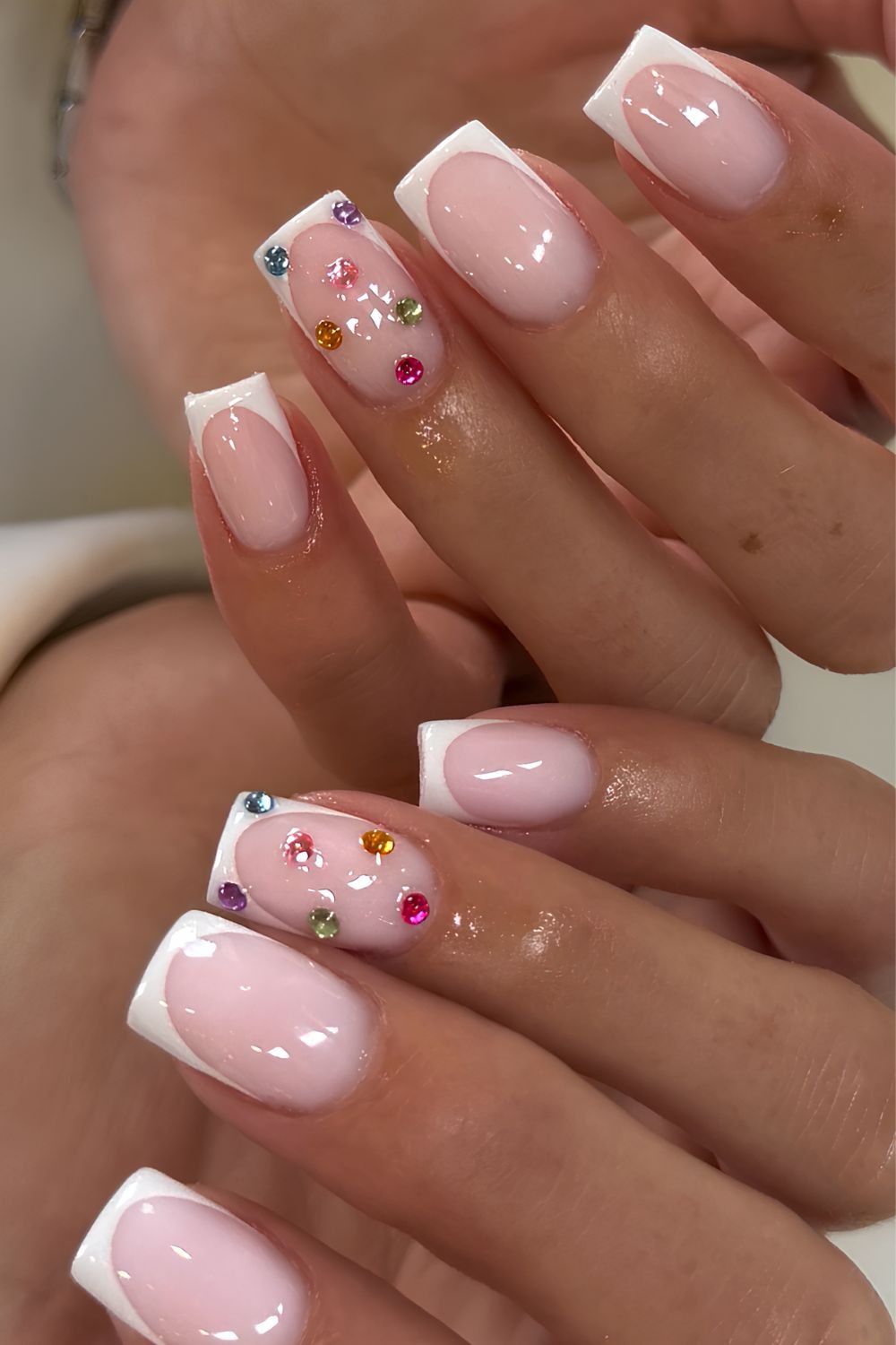White French manicure with colorful gem accents