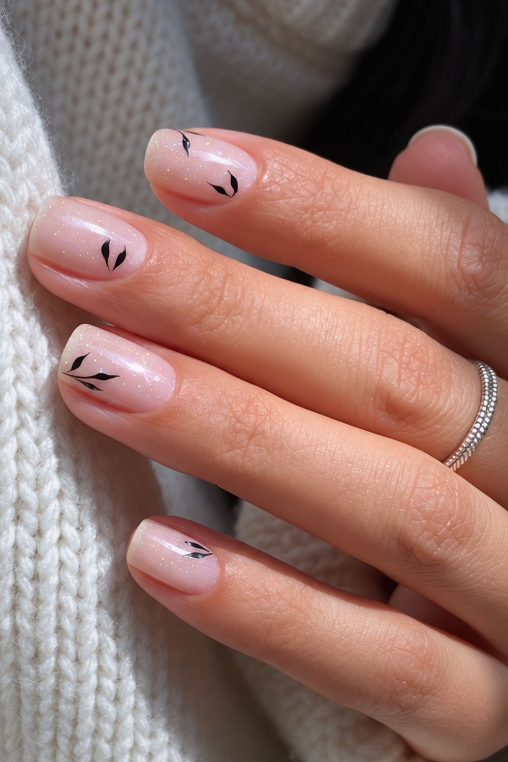 Sheer shimmery white nails with black leaf design